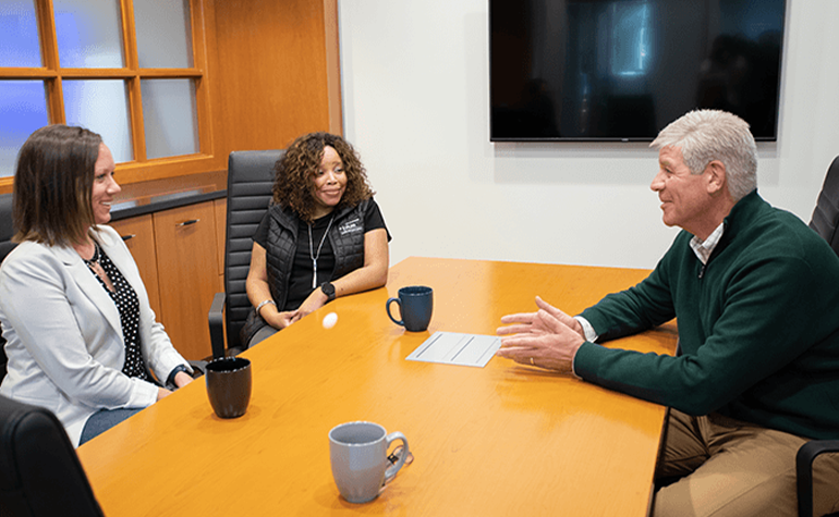 man meeting with two women in conference room