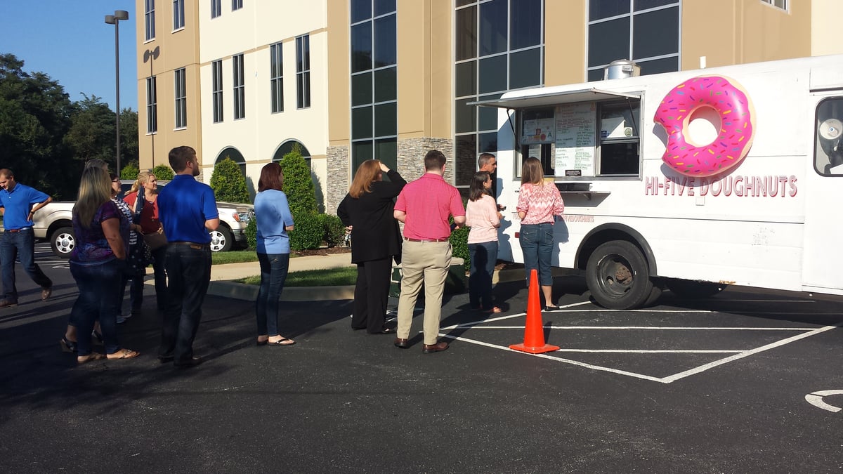 Employees line up in front of a doughnut foodtruck in the Kentucky office parking lot