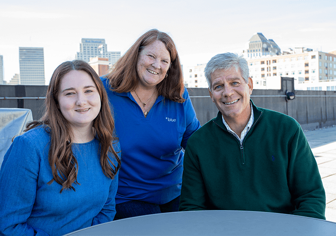 three employees posing for a picture on office patio