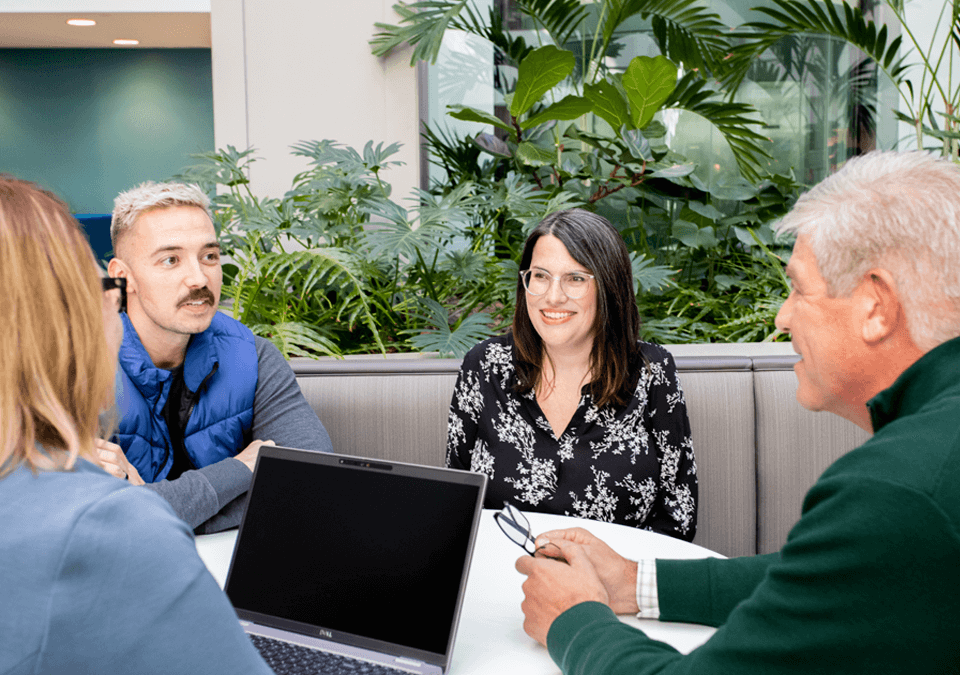 group of business professionals sitting around a table talking