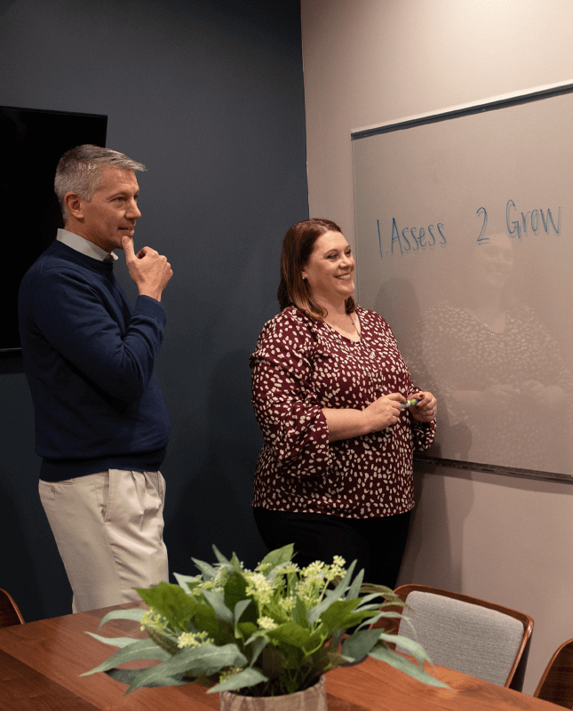 man and woman standing in front of white board
